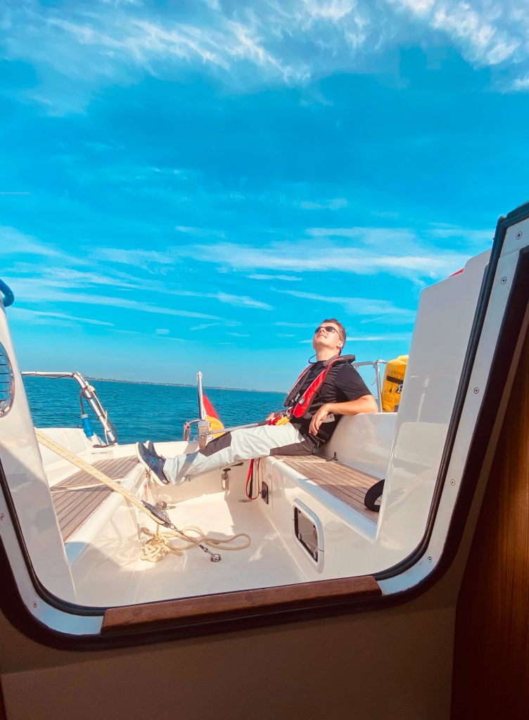 Segler im Seegelboot bei blauem Himmel